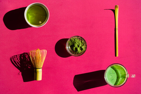 Background of matcha drink and powder with chasen and chashaku