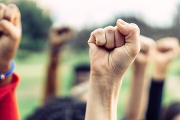 close-up of a woman's clenched fist raised in protest in favour of feminism