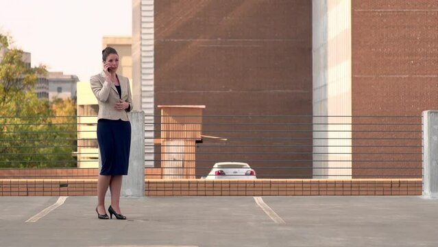 Businesswoman walks toward camera on the phone