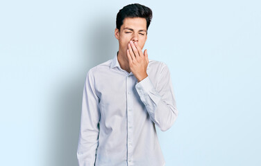 Young hispanic business man wearing business clothes bored yawning tired covering mouth with hand. restless and sleepiness.