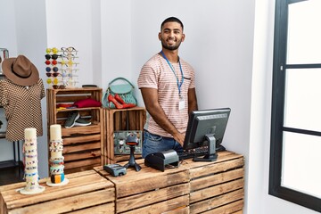 Young arab man smiling confident working at clothing store