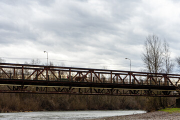 Naklejka premium Old rusty bridge over Tysa river near Khust, Carpathians mountains 