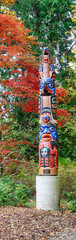 Northwest totem pole amid brightly colored autumn leaves