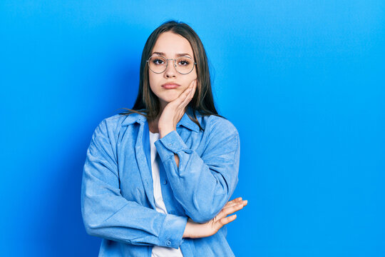 Young hispanic girl wearing casual clothes and glasses thinking looking tired and bored with depression problems with crossed arms.