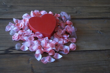 Red Heart Box Surrounded by Pink Flower Petals on Dark Brown Panels