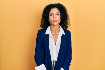 Young latin girl wearing business clothes with serious expression on face. simple and natural...