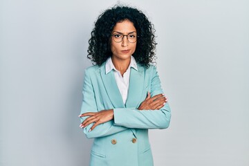 Young latin girl wearing business clothes and glasses skeptic and nervous, disapproving expression...