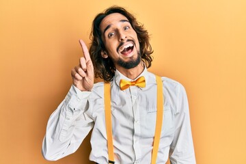 Young hispanic man wearing hipster elegant look showing and pointing up with finger number one...