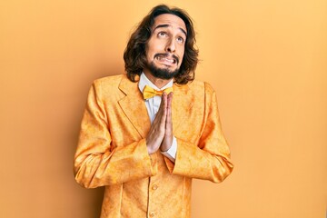 Young hispanic man wearing hipster elegant look begging and praying with hands together with hope...