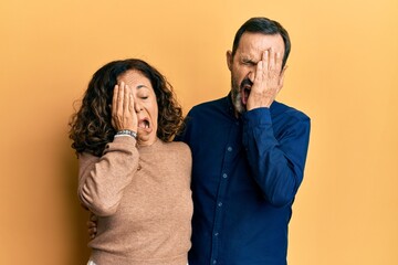 Middle age hispanic couple wearing casual clothes yawning tired covering half face, eye and mouth with hand. face hurts in pain.