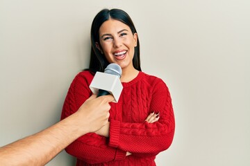 Beautiful brunette woman being interviewed by reporter holding microphone happy face smiling with...