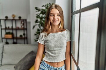 Fototapeta premium Adorable girl smiling confident leaning on window at home