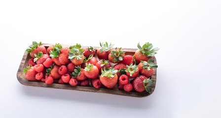 fresh strawberries over a wood plate  isolated on white background.  Natural product.