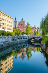 Franciscan Church of the Annunciation and Triple Bridge reflected in Ljublanica river, Ljubljana,...