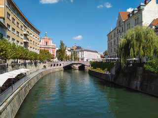 Naklejka premium Franciscan Church of the Annunciation and Triple Bridge reflected in Ljublanica river, Ljubljana, Slovenia