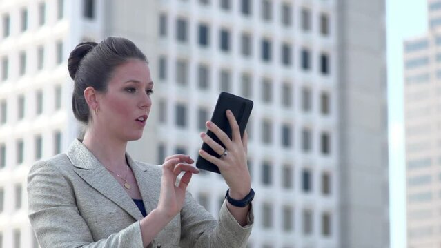 Excited Businesswoman uses tablet in downtown area