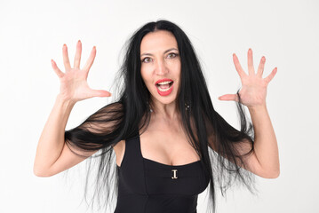 Portrait of a beautiful brunette woman in an explosive fighting pose ready to fight and scratch in...