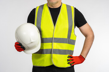 Construction helmet. Protective helmet for construction work. Worker in yellow vest holds white...