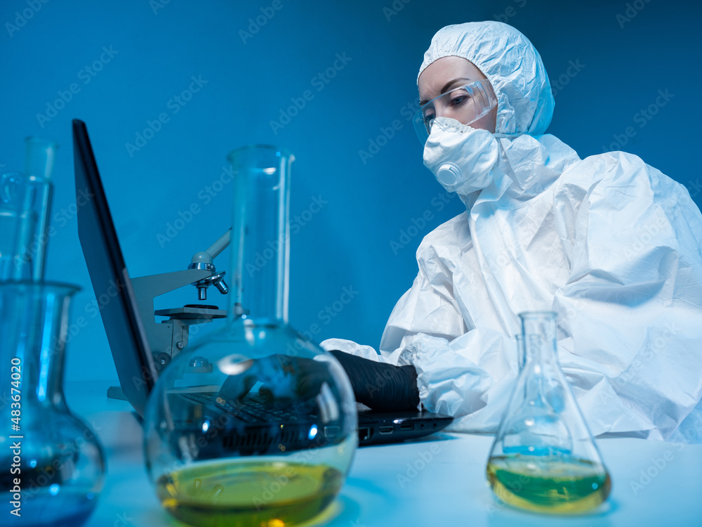 Aufkleber scientist is typing on laptop. chemist works with computer. chemist at table in laboratory. woman in