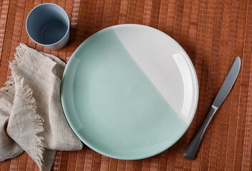 empty plate with knife beside on wooden table