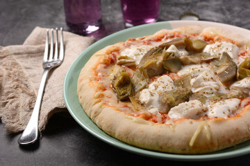 Italian pizza with mozzarella, tomato and artichokes on gray background