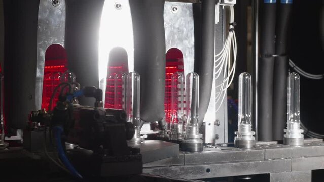 One of the stages of bottle manufacturing: PET preform is being installed on a conveyor