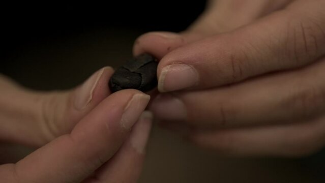 Close up shot of a girl hands touching and breaking a cocoa bean. Detail chocolate texture view from inside 4K.