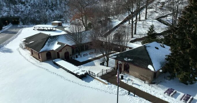 Horseshoe Curve Visitors Center covered in winter snow. American flag. Aerial.