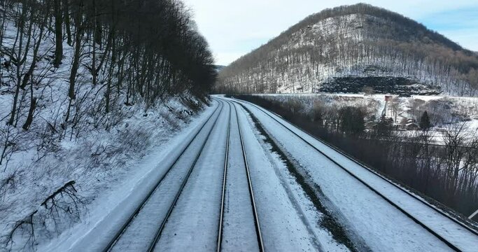 Train conductor engineer point of view POV shot. Train travel in winter snow mountain pass. Smooth glide.