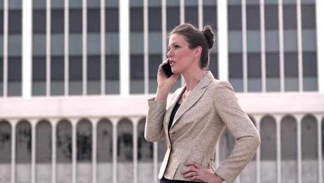Sharp Businesswoman having phone conversation outdoors