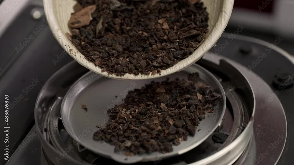 Poster weighing ground cocoa on a scale in order to develop new products and improve the quality of chocola