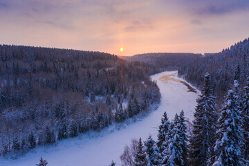 frozen river from above and snow-covered forest in winter