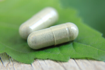 close up photo of herbal capsule from organic herb for health care using. alternative multivitamins for good living life healthy eating. selective focus.