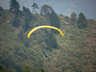 Yellow Paraglider Flying near the Green Mountains in Belmira, Antioquia, Colombia