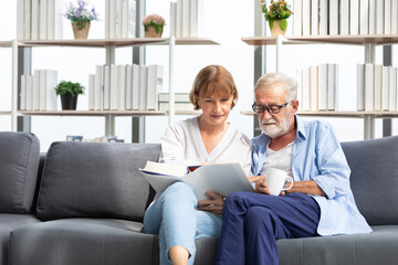 senior couple reading a book and self learning in living room