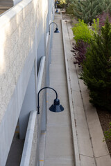 Obraz premium Concrete alley lined by shrubbery and lit with ornamental black lights