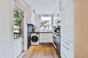 Spectacular kitchen with black countertop and washing machine - obrazy, fototapety, plakaty