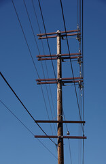 Electricity distribution pylon and power lines under blue sky