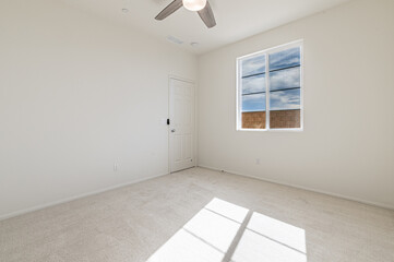 An empty new bedroom with bright windows in an upscale modern neighborhood.