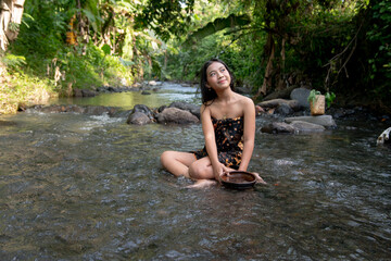 Beautiful young Asian girl rests and bathes in the river