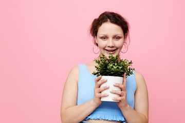 portrait of a young woman holding a pot with a flower isolated backgrounds unaltered