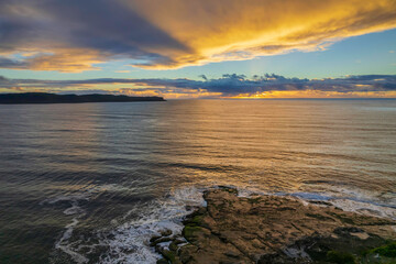 Aerial sunrise seascape with overcast sky and rain clouds