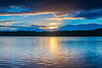 Sunrise waterscape with cloud covered sky