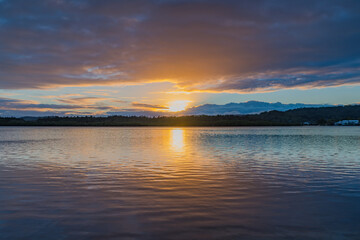 Sunrise waterscape with cloud covered sky
