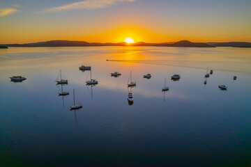 Fototapeta premium Aerial sunrise waterscape with boats