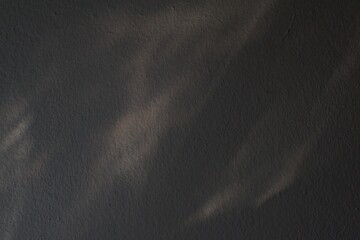 black cement wall texture background with abstract sunlight shadow