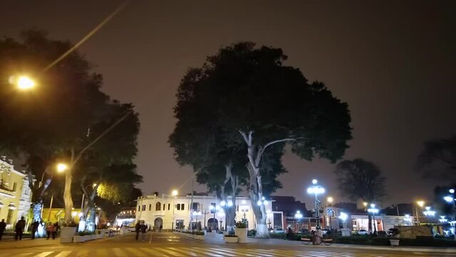 Night street hyperlapse in Barranco downtown at Lima Peru with people, buses and cars passing by