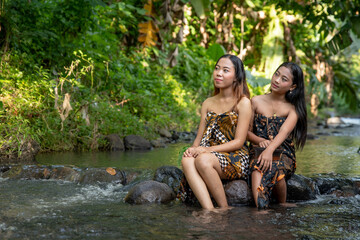 Fototapeta premium Portrait of beautiful two young Asian girls in river