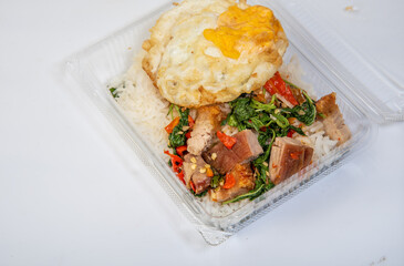 Crispy pork rice with fried egg, Asian street food, on a white background