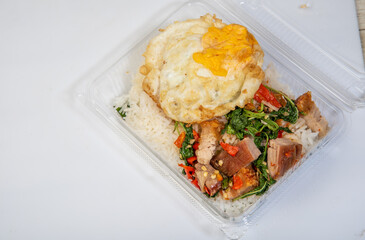 Crispy pork rice with fried egg, Asian street food, on a white background